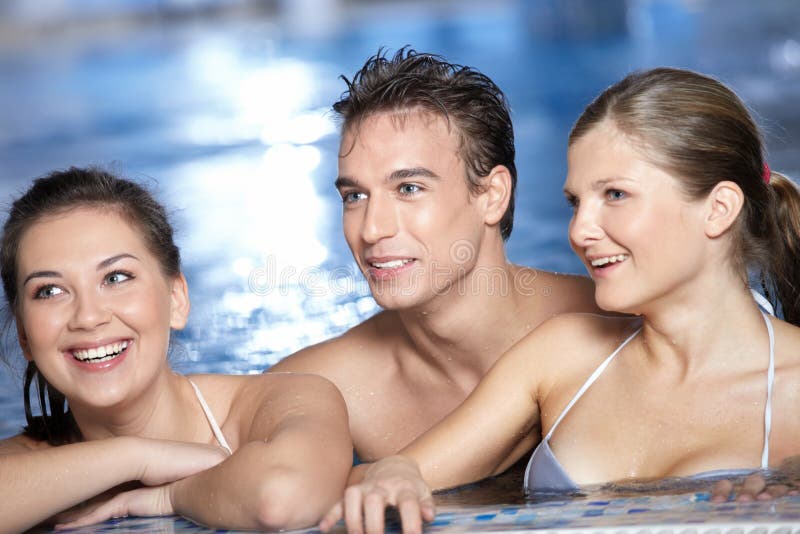 I sorrisi e gli amici che sono in piscina guardare lontano.