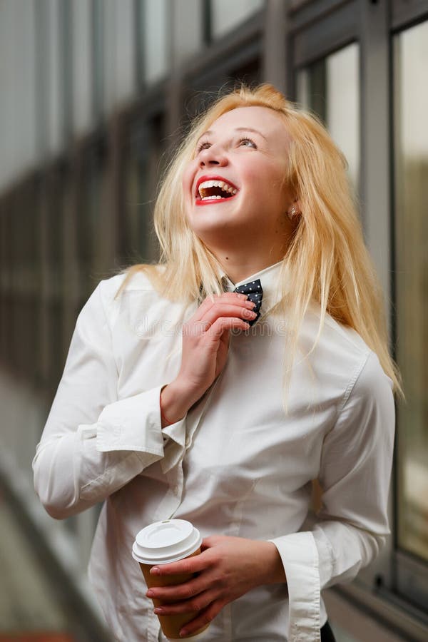 Laughing Ginger Girl with Coffee Cup Standing in Hall Stock Image