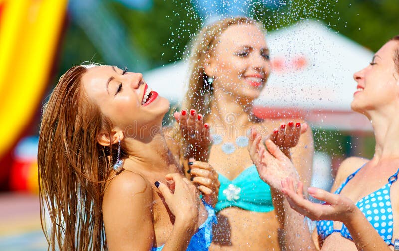 Laughing girls having fun under summer shower