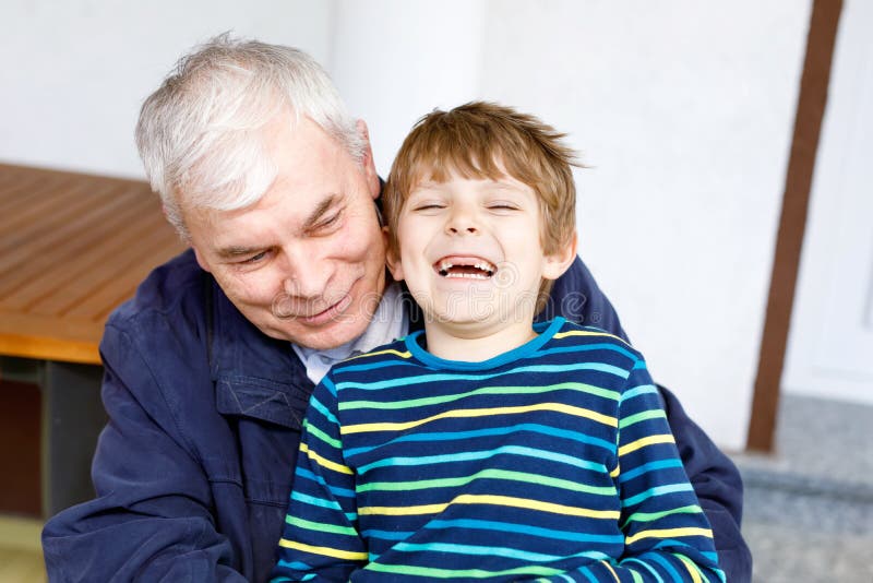 Laughing grandfather with his grandson as they play together. royalty free stock images Laughing grandfather with his grandson as they play together. royalty free stock images