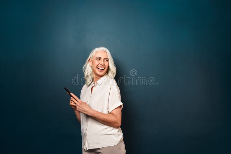 Laughing mature old woman using mobile phone. royalty free stock images Laughing mature old woman using mobile phone. royalty free stock images