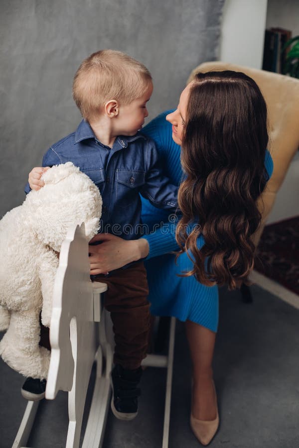 Laughing son and smiling mother in studio.