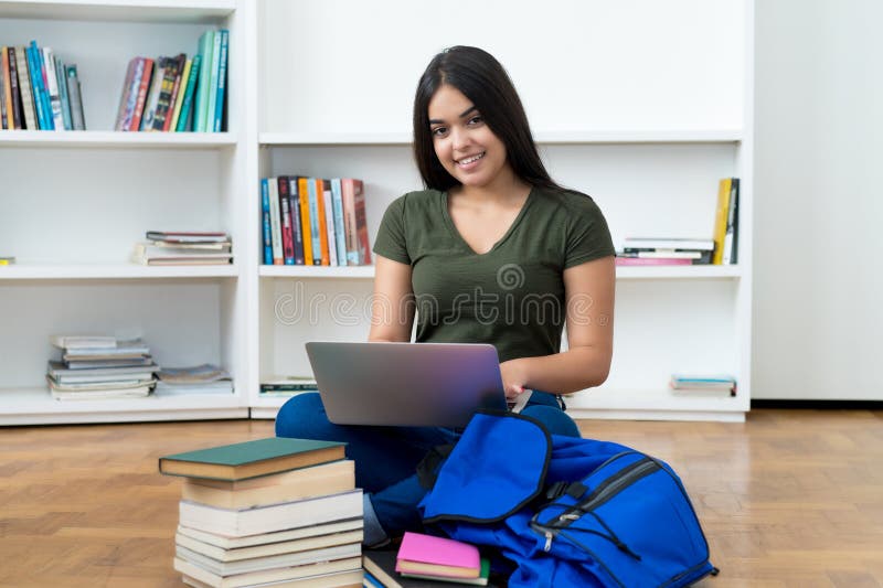 Laughing spanish computer science student with laptop stock image