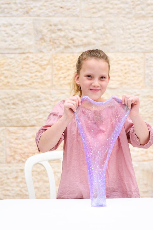 Laughing Teen Freckle Girl Making A Purple Slime And Looking At Camera