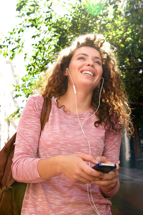 Laughing teen girl on cellphone with headphones outside stock image Laughing teen girl on cellphone with headphones outside stock image