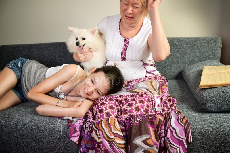 Laughing teen girl and her grandmother with the dog