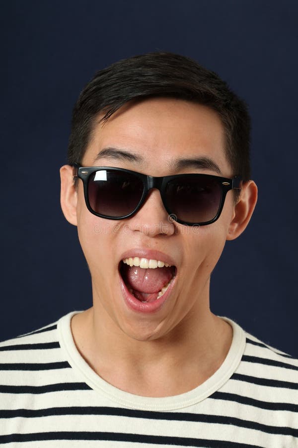 Laughing young Asian man in sunglasses