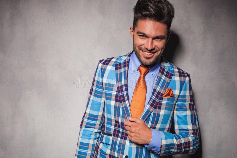 Laughing young man in checkered suit and orange tie