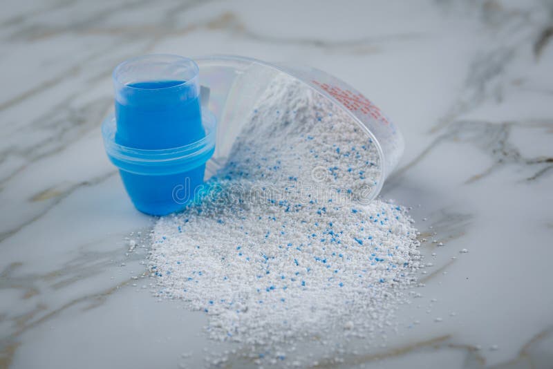 Laundry Detergent Powder and Blue Liquid Gel in Measuring Cup Stock