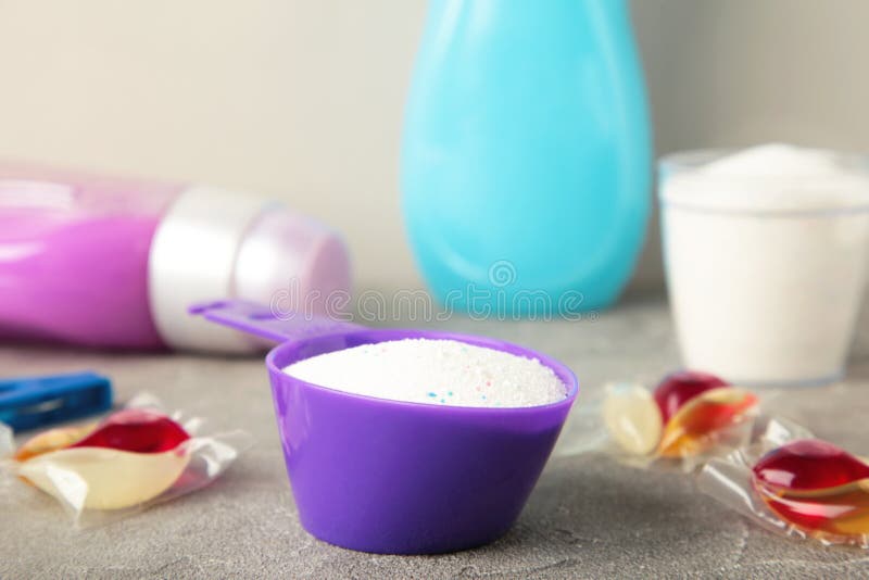 Laundry Detergents with Washing Powder and Capsules on Grey Background