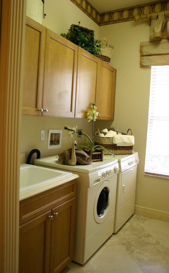 Nové, moderné práčovňa s umývadlom, skrine a spotrebičmi.