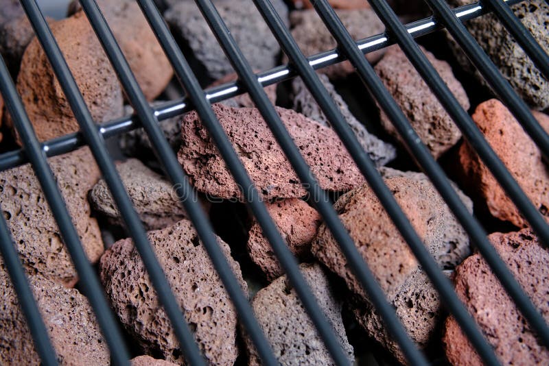 Lava Stone for Grilling. the View through the Blurred Grill Grate. Closeup Stock Photo Image
