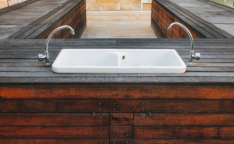 Lavabo de lavado a mano de la porcelana fijado en una plataforma de madera en un jardín elegante moderno imagen de archivo Lavabo de lavado a mano de la porcelana fijado en una plataforma de madera en un jardín elegante moderno imagen de archivo