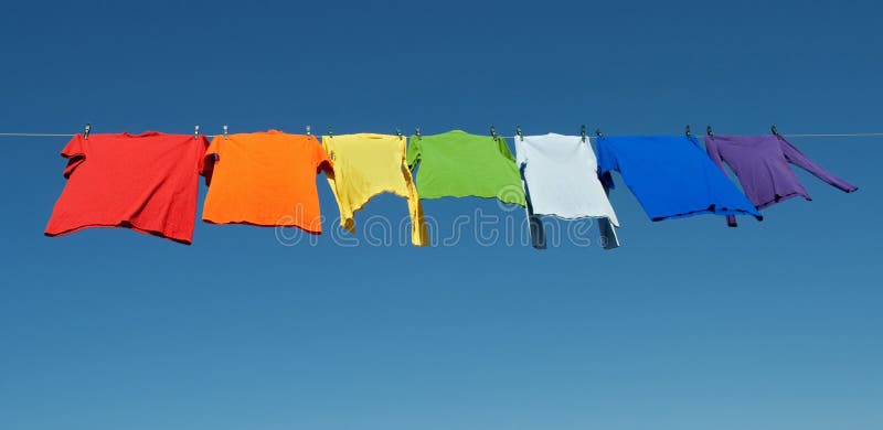 Lavadero del arco iris, camisas brillantes en una cuerda para tender la ropa