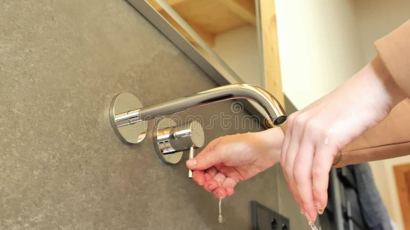 Lavado de manos bajo agua corriente en el concepto de limpieza e higiene del cuarto de baño