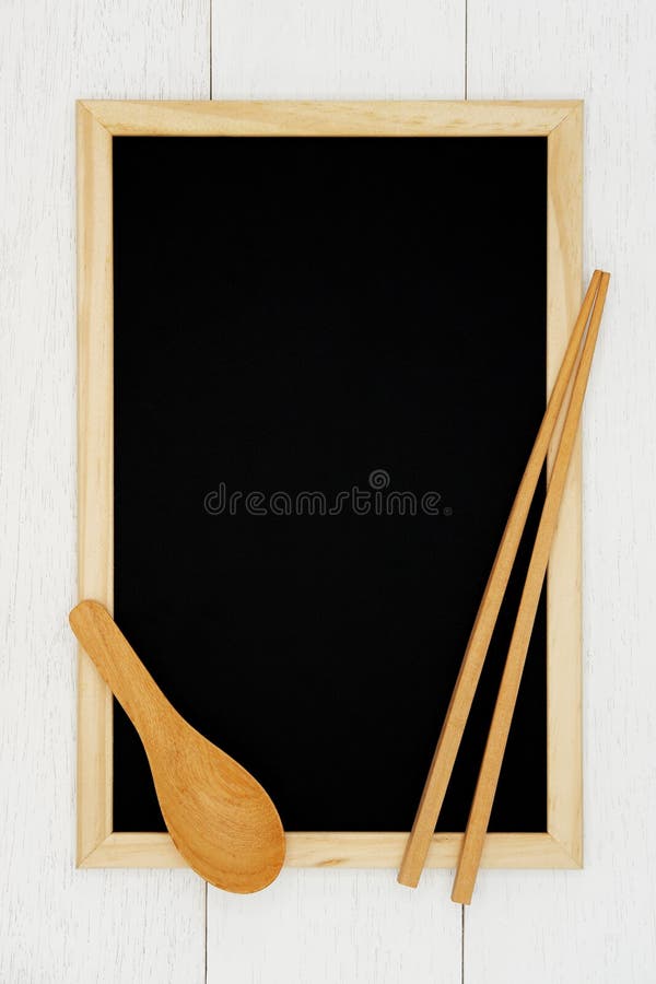 Lavagna in bianco con il cucchiaio ed il bastoncino di legno sul fondo di legno bianco della plancia fotografia stock Lavagna in bianco con il cucchiaio ed il bastoncino di legno sul fondo di legno bianco della plancia fotografia stock