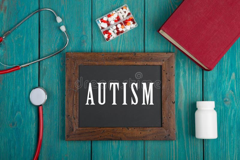 Lavagna con testo & x22; Autism& x22; , libro, pillole e stetoscopio su fondo di legno blu fotografie stock libere da diritti Lavagna con testo & x22; Autism& x22; , libro, pillole e stetoscopio su fondo di legno blu fotografie stock libere da diritti