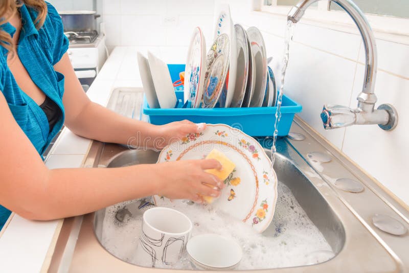 Domestic chores - Washing the dishes in the kitchen sink. Domestic chores - Washing the dishes in the kitchen sink