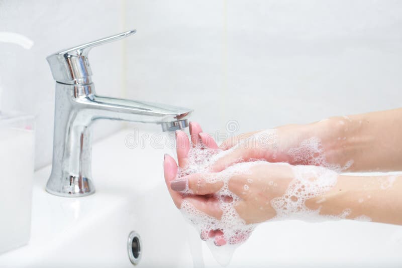 Lavare le mani con il sapone sotto il rubinetto con acqua immagini stock Lavare le mani con il sapone sotto il rubinetto con acqua immagini stock