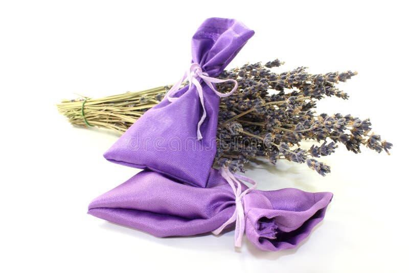 Dried lavender flowers and lavender bags against white background