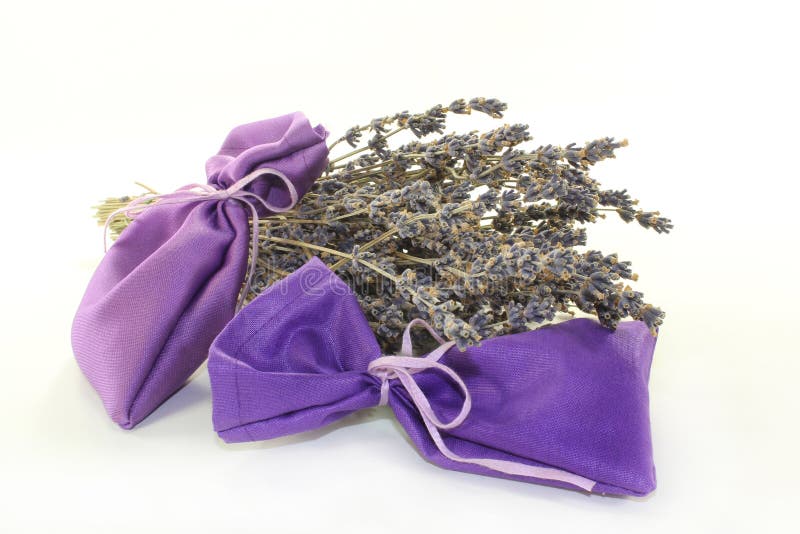 Dried lavender flowers and lavender bags against white background