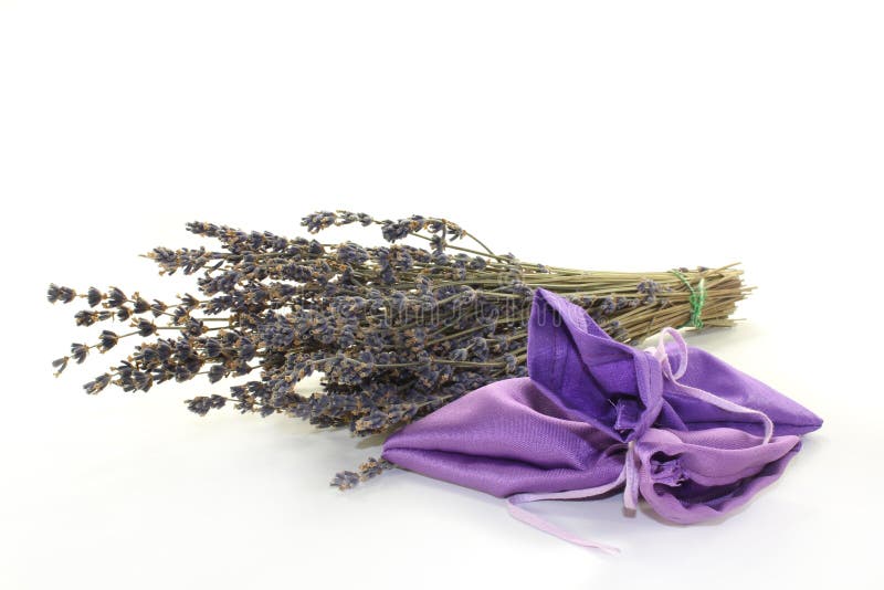 Dried lavender flowers and lavender bags against white background