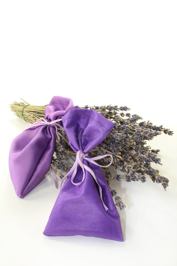 Dried lavender flowers and lavender bags against white background