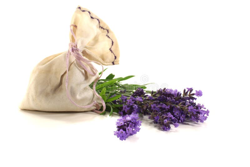 Lavender bag with fresh flowers and green leaves on a light background. Lavender bag with fresh flowers and green leaves on a light background