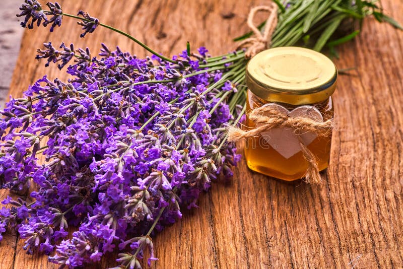 Lavender essential oil, bunch of lavender flowers on wooden board