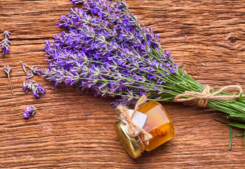 Lavender essential oil, bunch of lavender flowers on wooden board