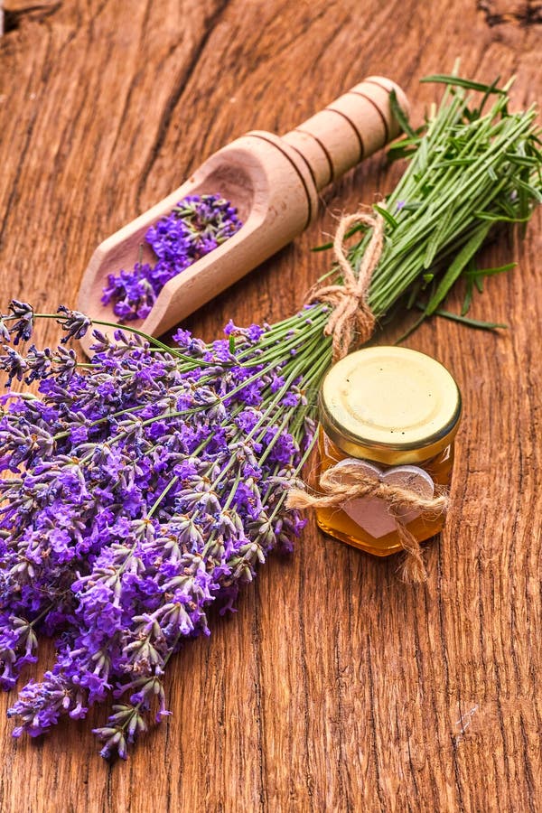 Lavender essential oil, bunch of lavender flowers on wooden board