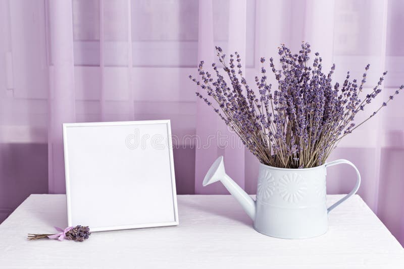 Lavender flowers in watering can and photo frame mock-up on window with tulle cloth background