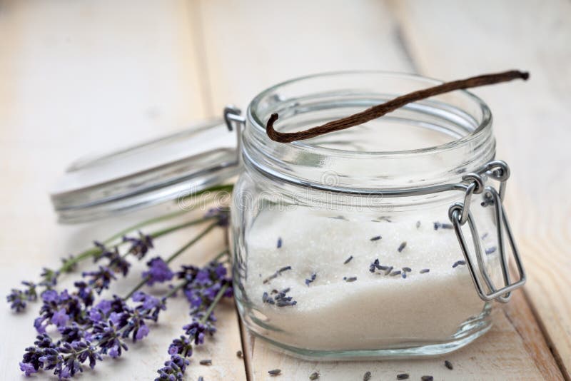 Vanilla pod on jar with lavender sugar, fresh lavender on a light wooden background. Vanilla pod on jar with lavender sugar, fresh lavender on a light wooden background