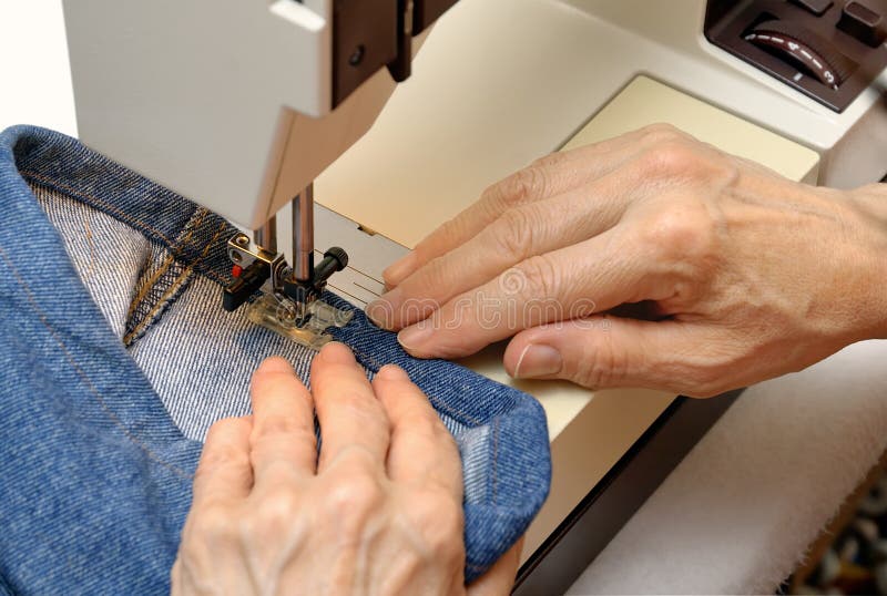 Lavorando ad una macchina per cucire fotografie stock libere da diritti Lavorando ad una macchina per cucire fotografie stock libere da diritti