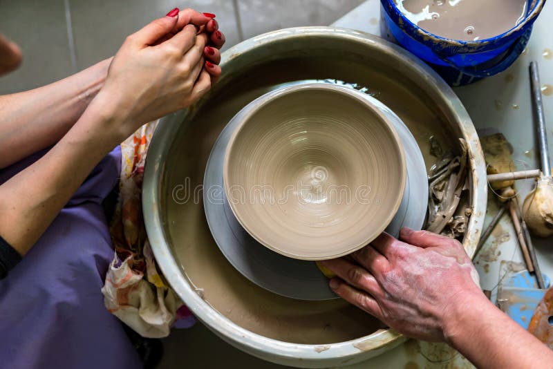 Lavorando alla fine della ruota del ` s del vasaio immagini stock Lavorando alla fine della ruota del ` s del vasaio immagini stock