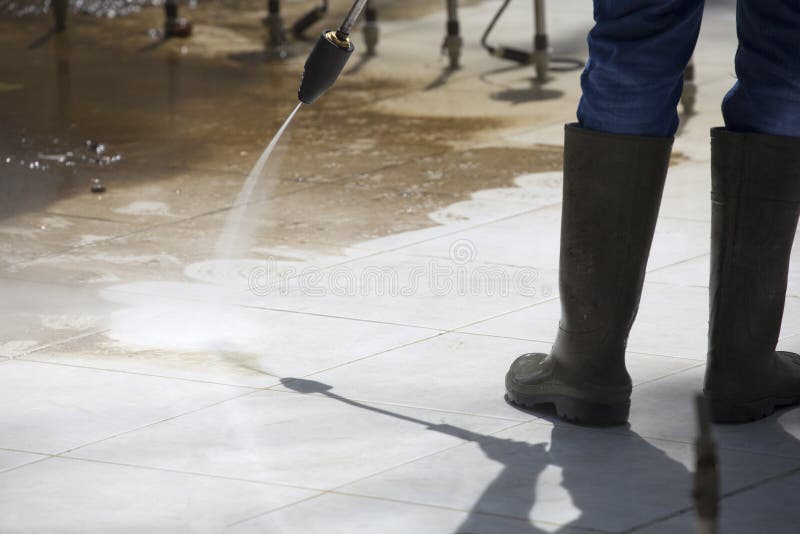 Lavoratore che pulisce una fontana dalla rondella di pressione immagini stock libere da diritti Lavoratore che pulisce una fontana dalla rondella di pressione immagini stock libere da diritti