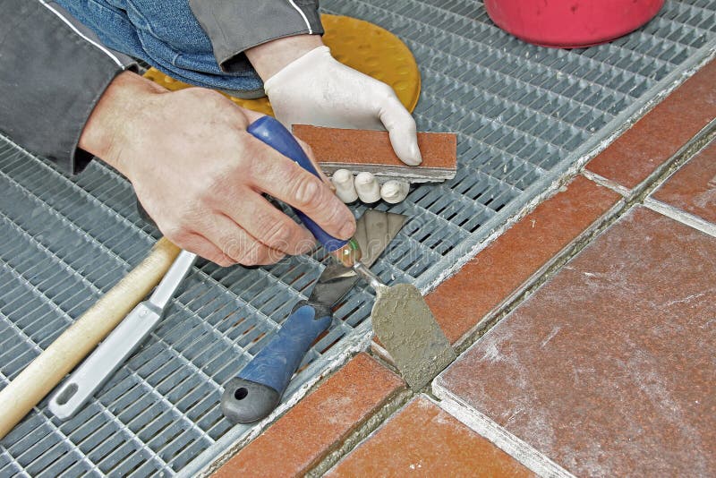 Lavoratore che ripara e che riempie di malta patio fotografia stock libera da diritti Lavoratore che ripara e che riempie di malta patio fotografia stock libera da diritti