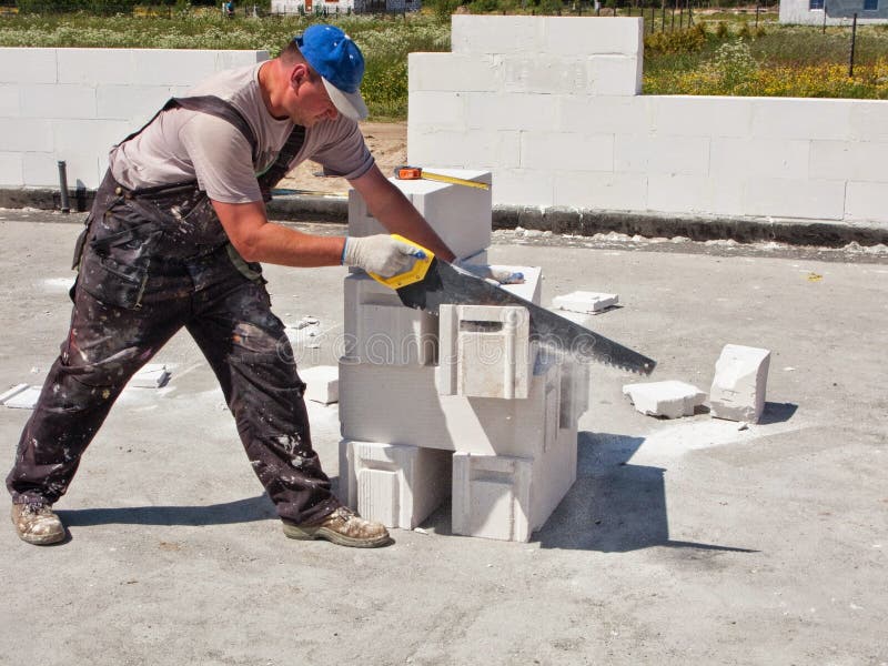 Lavoratore che taglia i blocchi in calcestruzzo fotografie stock libere da diritti Lavoratore che taglia i blocchi in calcestruzzo fotografie stock libere da diritti