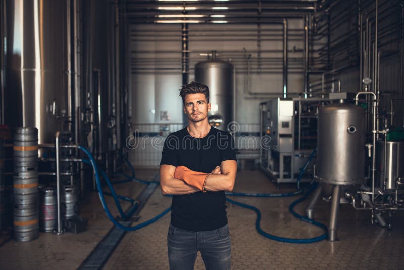Lavoratore con attrezzatura industriale alla fabbrica di birra immagini stock Lavoratore con attrezzatura industriale alla fabbrica di birra immagini stock