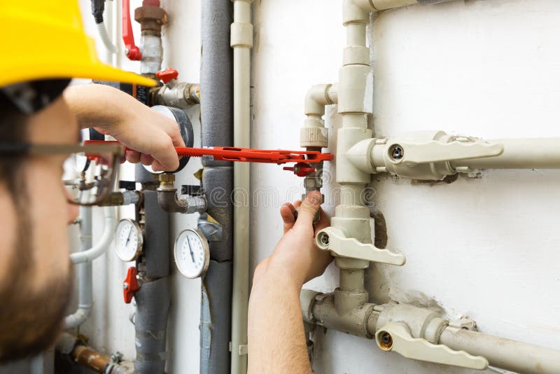 Lavoratore del tecnico che fa i lavori di manutenzione per syste di riscaldamento immagine stock Lavoratore del tecnico che fa i lavori di manutenzione per syste di riscaldamento immagine stock