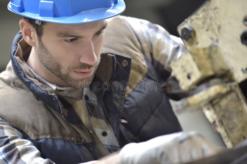 Lavoratore dell'industria che lavora ad una macchina fotografie stock libere da diritti Lavoratore dell'industria che lavora ad una macchina fotografie stock libere da diritti