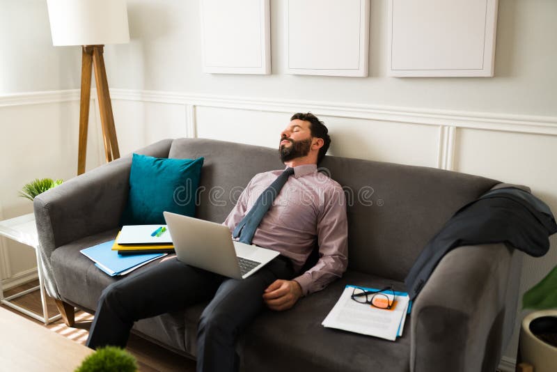 Lavoratore esausto che sta facendo un pisolino mentre sta lavorando fotografia stock