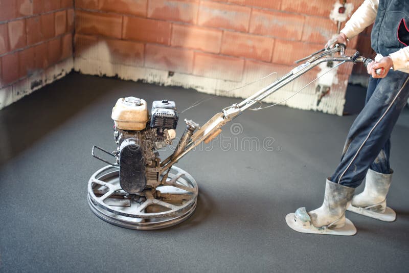 Lavoratore maschio con lo strumento della cazzuola di potere che finisce pavimento di calcestruzzo, superficie di calcestruzzo re fotografie stock Lavoratore maschio con lo strumento della cazzuola di potere che finisce pavimento di calcestruzzo, superficie di calcestruzzo re fotografie stock