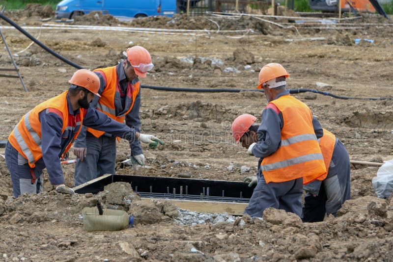 Lavoratori al fondamento del calcestruzzo del cantiere fotografie stock libere da diritti Lavoratori al fondamento del calcestruzzo del cantiere fotografie stock libere da diritti