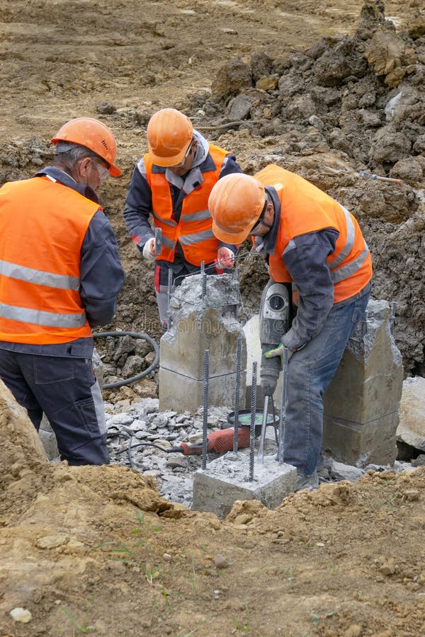 Lavoratori al taglio che del cantiere un martello pneumatico accatasta è tagliato fotografia stock libera da diritti Lavoratori al taglio che del cantiere un martello pneumatico accatasta è tagliato fotografia stock libera da diritti