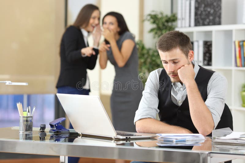Lavoratori che opprimono un collega all'ufficio fotografia stock Lavoratori che opprimono un collega all'ufficio fotografia stock