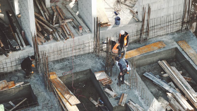 Lavoratori Industriali Che Lavorano Nel Settore Dell'Edilizia Lavorativa Lavorano In Cemento Di Cemento Concreto Nudo Con Strumen