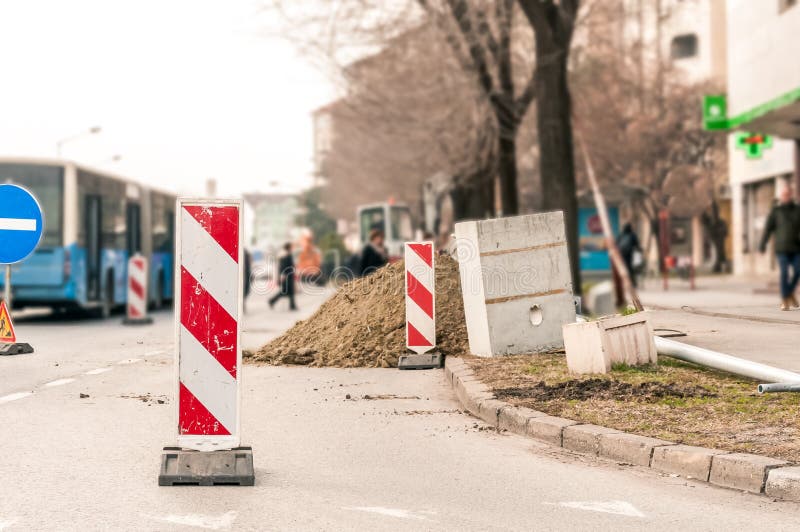 Lavori avanti il sito di ricostruzione della via con il segno e recinti come barriera della strada immagini stock Lavori avanti il sito di ricostruzione della via con il segno e recinti come barriera della strada immagini stock