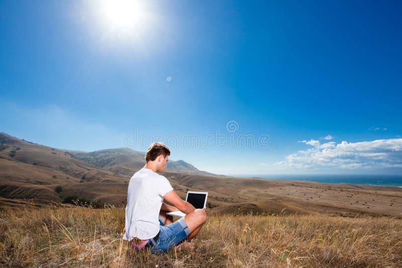 Lavoro dell'uomo sul computer portatile nelle montagne immagini stock libere da diritti Lavoro dell'uomo sul computer portatile nelle montagne immagini stock libere da diritti