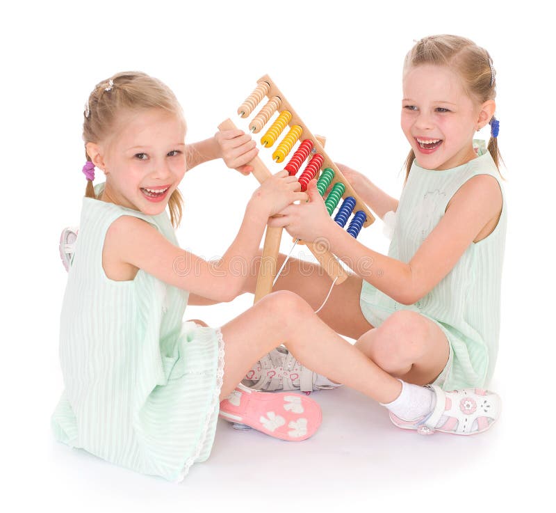 Lavoro sveglio delle sorelle nell'ambiente di Montessori. fotografia stock Lavoro sveglio delle sorelle nell'ambiente di Montessori. fotografia stock
